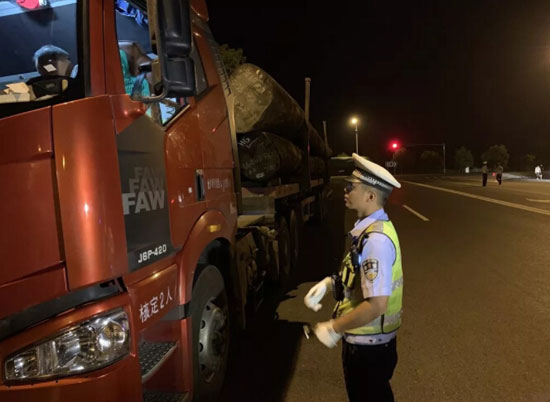 圖為交警正在對過往車輛進(jìn)行過磅檢查